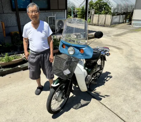バイクとその横に立っている男性の写真