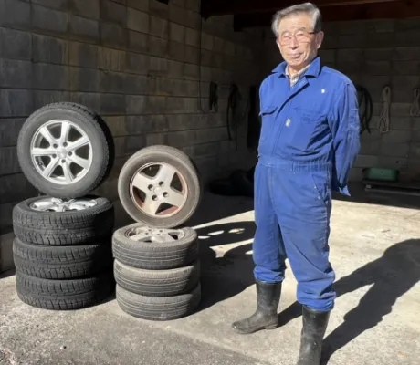 タイヤとその横に立っている男性の写真